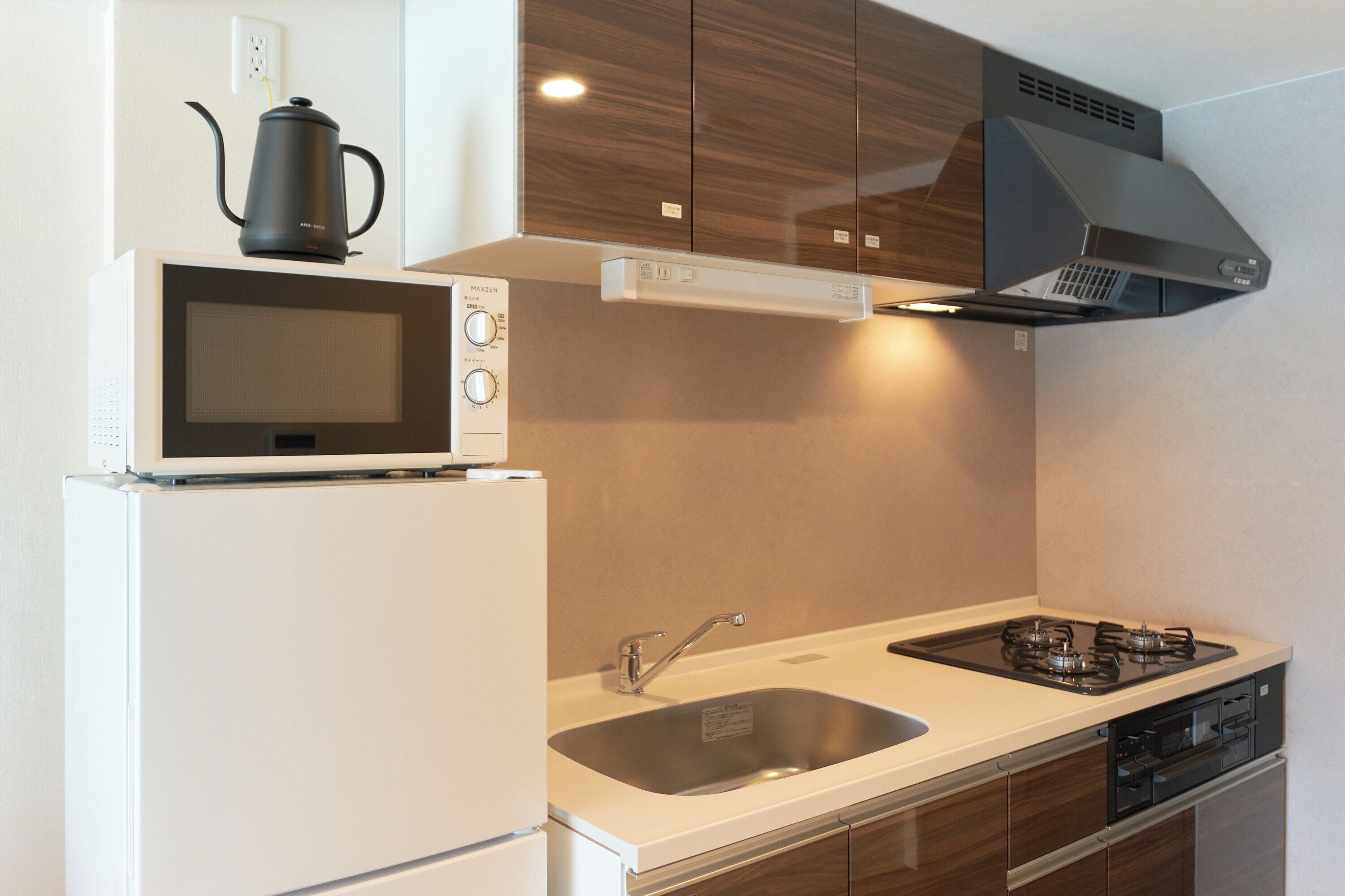 A modern kitchen with a built-in microwave, stove, and sink.