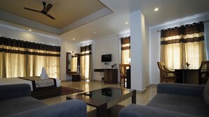 A spacious living room with a flat-screen TV, a coffee table, and a seating area with sofas. - Terrace Valley Hotel (Gangtok)