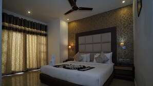 A modern bedroom with a large bed, a ceiling fan, and decorative wall panels. - Terrace Valley Hotel (Gangtok)