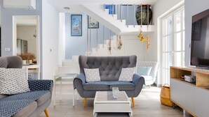 A modern living room with a grey sofa, a white coffee table, and a staircase leading to an upper level. - Vacation home Mala by Interhome (Murter/Murter)
