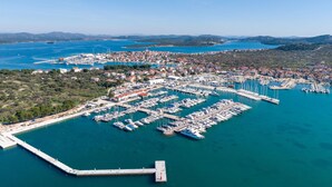 An aerial view of a marina with numerous boats docked, surrounded by residential buildings and greenery. - Vacation home Mala by Interhome (Murter/Murter)