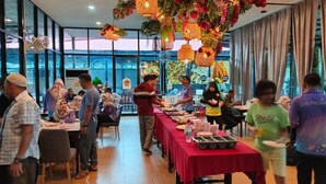 Egy étkező, ahol az asztalok meg vannak terítve, egy büféasztal és dekoratív, felakasztott lámpák láthatók.