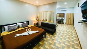 Una habitación de hotel con cama, sofá, escritorio y televisión.