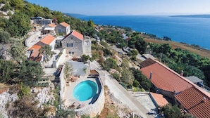 A coastal property with a swimming pool, stone buildings, and a view of the sea. - Luxury Villa in Zavala w/pool (Zavala, Jelsa)