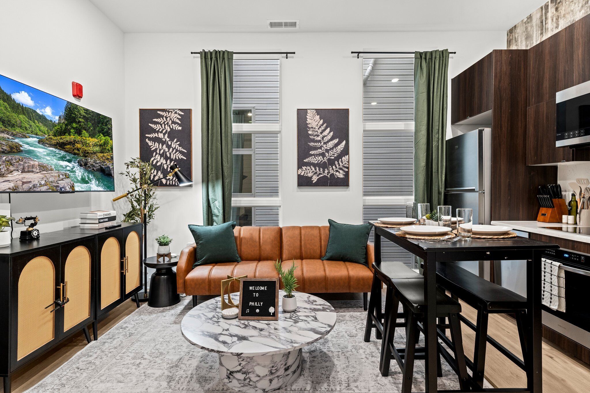 A modern living room with a sofa, coffee table, and dining area.