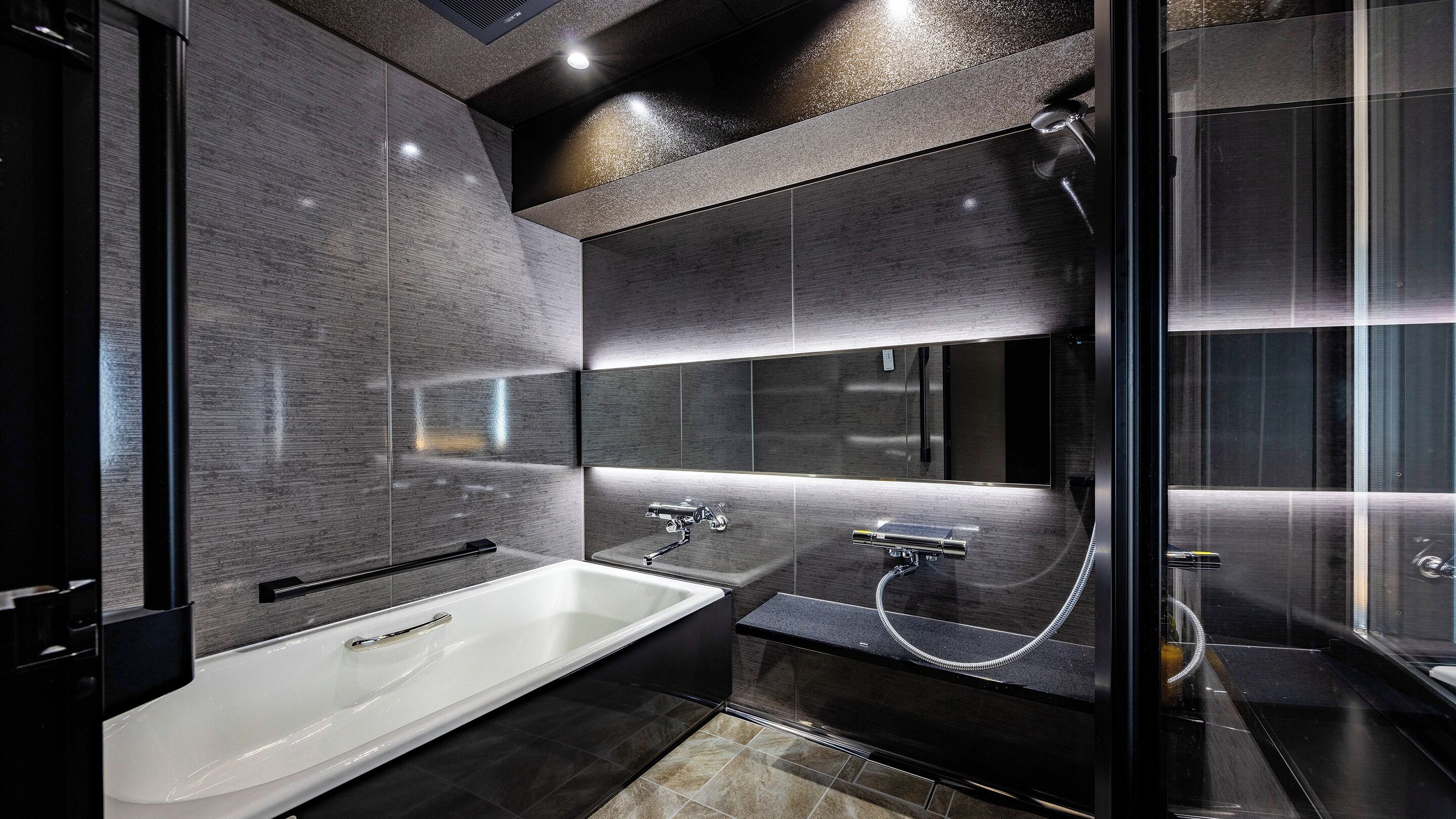 Een moderne badkamer met een ruime badkuip, een aparte douche en een douchecabine met glazen wanden.