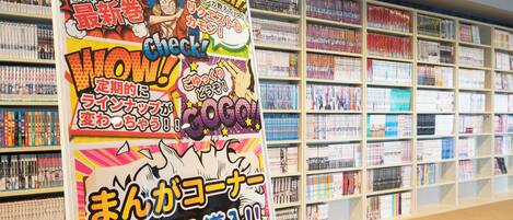 A manga display with vibrant posters and a bookshelf filled with manga volumes.