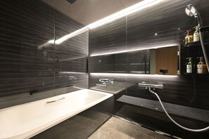 Vierpersoonskamer in Japanse stijl | Badkamer | Een bad/douchecombinatie, een haardroger, pantoffels, handdoeken