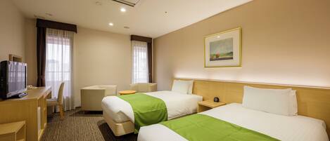 A hotel room with two beds, a desk with a television, a chair, and a picture on the wall.