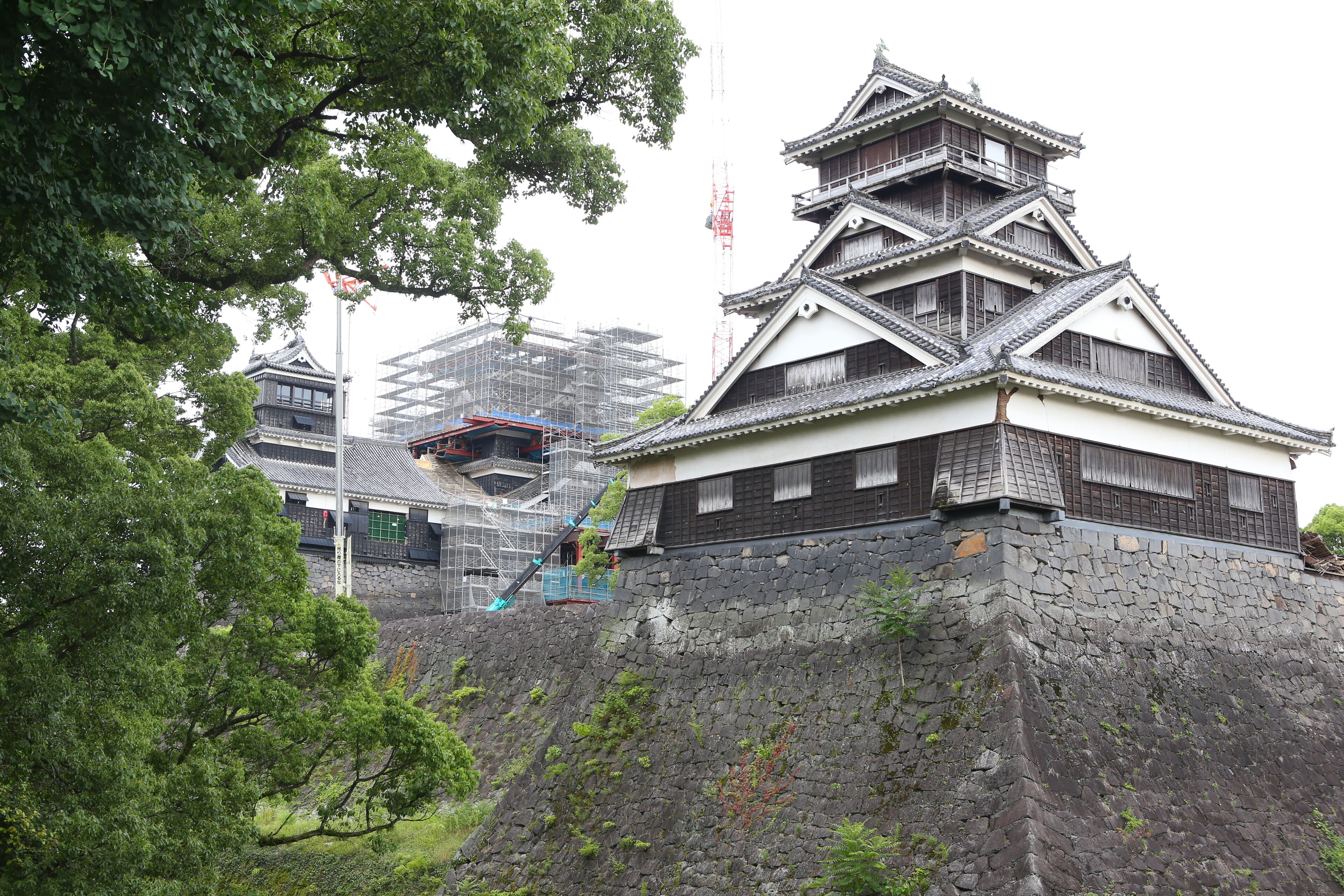 Un château japonais traditionnel, doté de murs en pierre et de plusieurs niveaux.