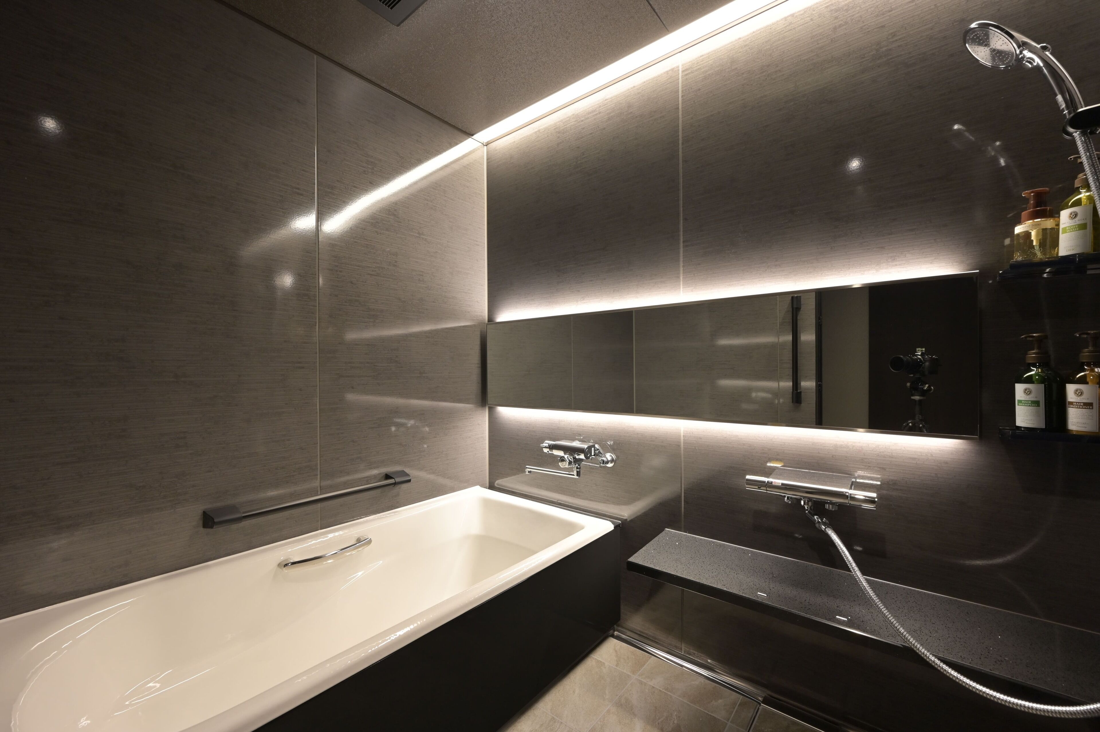 A modern bathroom with a large bathtub, a separate shower area, and a vanity with a mirror.