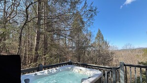 A hot tub on a wooden deck surrounded by trees. - Rooster's Perch Cabin at Country Manor Acres in Townsend, TN (Townsend)