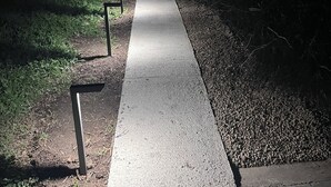 A nighttime view of a sidewalk leading to a building with a light source illuminating the path. - Salida Cottage (Salida)