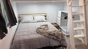 A bunk bed with a grey quilt, a patterned throw blanket, and a white headboard. - Salida Cottage (Salida)