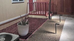 A house with a red door, a small porch, and a wooden fence. - Salida Cottage (Salida)
