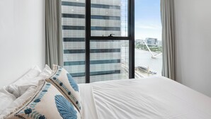 A hotel room with a large window, a bed, and a view of a cityscape. - Centre of Brisbane at RiverFront (Brisbane City)