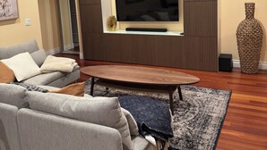 A modern living room with a sofa, a coffee table, and a television mounted on a wall. - Occidental college (Los Angeles)