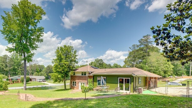 A single-story house with a green exterior, a front porch, and a small patio area. - Stay & Play Studio Near ATL Airport (College Park)