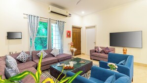 Una sala de estar con dos sofás, una mesa de centro y un televisor.