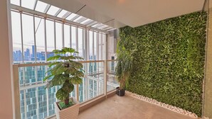 Une chambre moderne avec de grandes fenêtres, une plante en pot et un mur végétal.