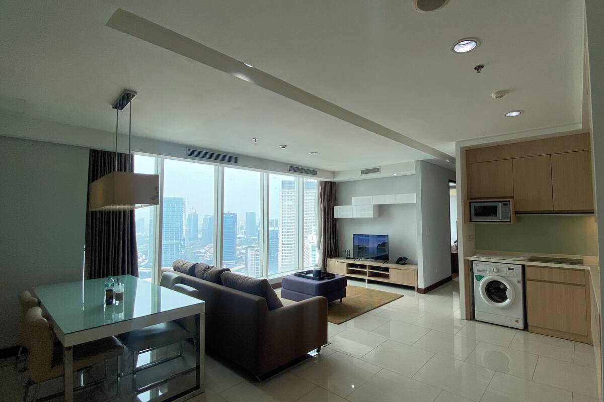 A modern apartment with a living room, dining area, and kitchenette.