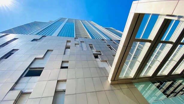 Un bâtiment moderne doté d’une façade en verre et d’un rez-de-chaussée carrelé.