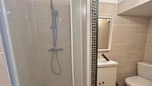 A bathroom with a shower, toilet, and sink.