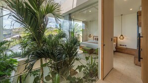 A modern interior with a glass balcony, a bed, and a dining area.