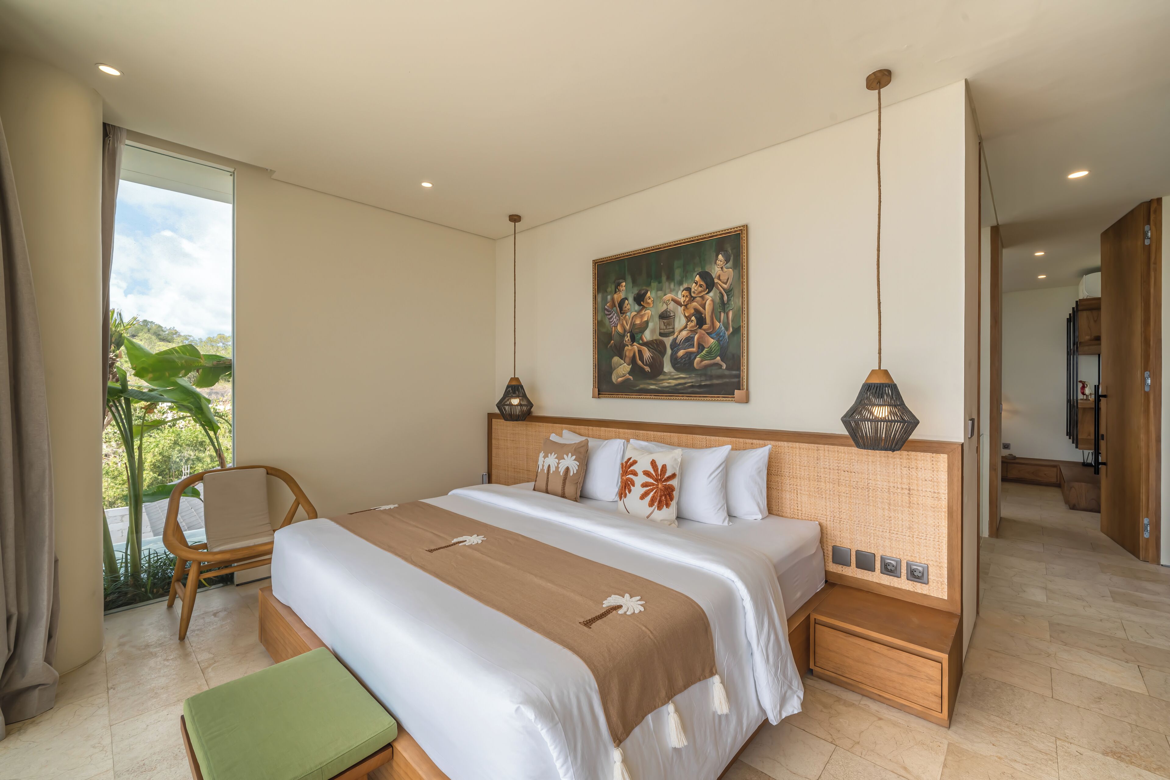 A modern hotel room with a large bed, a green chair, a painting on the wall, and a view of greenery outside.