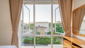A bedroom with a large window, a bed, a wooden desk, and a mirror. - Mandala Hill Private Pool Villa Estate Nusa Dua (Nusa Dua)