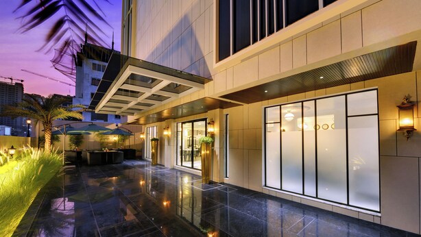 A modern hotel lobby with a reflective floor, large windows, and a seating area with umbrellas. - The Beacon Hotel NIBM Pune (Pune)