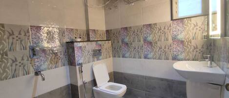 A bathroom with a shower, toilet, and sink.
