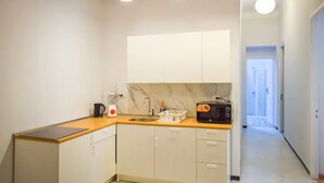 A compact kitchen with white cabinets, a microwave, a blender, and a sink. - Chic 2-bedroom Apartment in Heliopolis (Cairo Governorate)