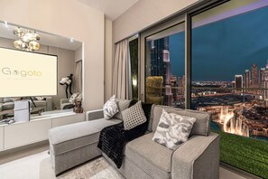 A modern living room with a sofa, a coffee table, and a large window offering a city view. - Gogoto1 2BR Burj Khalifa, Fountain View Dubai Mall (Dubai)