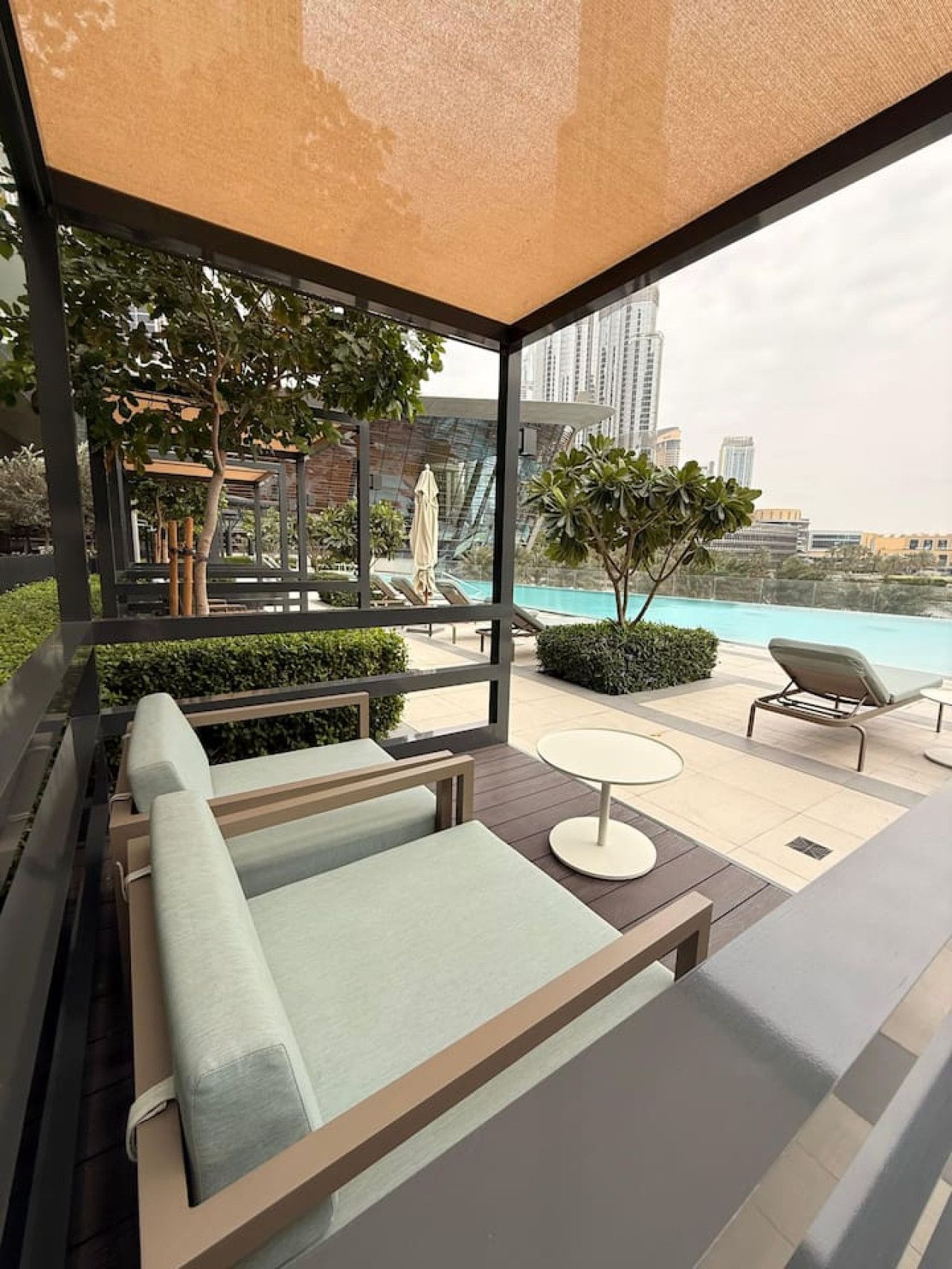 Un espace de détente extérieur moderne, doté de sièges et offrant une vue sur la piscine.