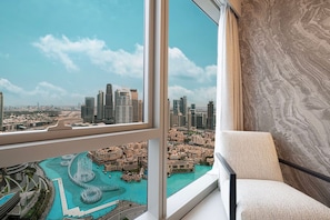 A high-rise interior with a large window offering a view of a cityscape and a waterfront area. - Gogoto1 2BR Burj Khalifa, Fountain View Dubai Mall (Dubai)