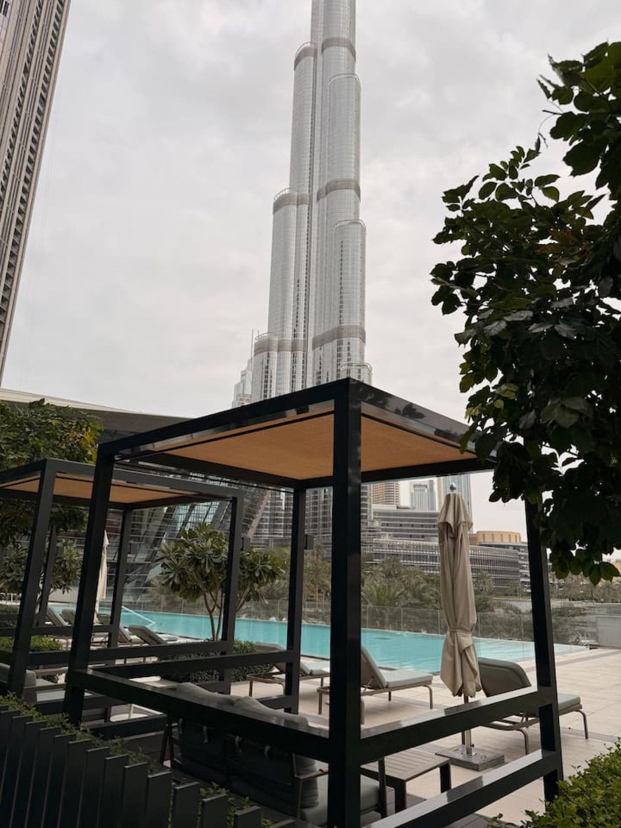 Een zwembad op het dak met ligbedden en uitzicht op de Burj Khalifa.