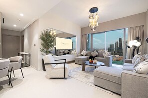 A modern living room with a large window, a sofa set, a coffee table, and a decorative plant. - Gogoto1 2BR Burj Khalifa, Fountain View Dubai Mall (Dubai)