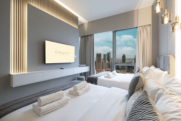 A hotel room with a city view, a flat-screen TV, two beds, and a large window.
