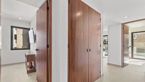 A modern interior with wooden doors, a built-in bench, and a large mirror. - Marsala 201: 2BR w/ Rooftop Pool - Walk to Beach (Bucerías)