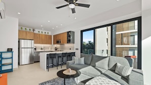 A modern kitchen with a central island, bar stools, and a built-in microwave. - Marsala 201: 2BR w/ Rooftop Pool - Walk to Beach (Bucerías)