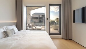 A modern hotel room with a large bed, a flat-screen TV, and a balcony with seating. - La Felicità (Shenzhen)