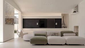 A modern living room with a sectional sofa, a large flat-screen TV, and a decorative Eiffel Tower model. - La Felicità (Shenzhen)