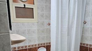 A bathroom with a sink, toilet, and bathtub. - Oasis Hostel (Abu Dhabi)