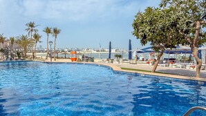A swimming pool with a view of the sea and a marina. - LUX The Shoreline Palm Island Suite 2 (Dubai)