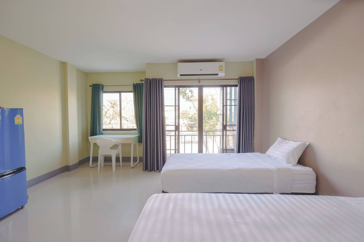 A hotel room with a bed, a desk, and a chair.