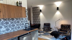 A modern kitchen with a wooden countertop, a built-in dishwasher, and a black chair. - Ketzin Havel modern apartment with private garden, close to the water (ketzin)