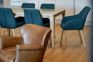 Un espace repas moderne avec une table en bois et des chaises recouvertes d’un tissu bleu.