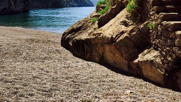 A coastal view with a rocky cliff, a clear blue sea, and a mountainous backdrop. - Torre Sponda - Torre, Private Beach (Positano)