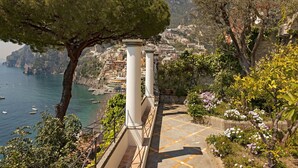 Une ville côtière avec un escalier descendant jusqu'à la plage, entourée de verdure et offrant une vue sur la mer.